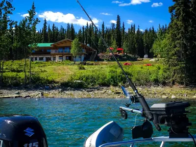 a boat in the water with a fishing pole at Southern Lakes Resort in Tagish