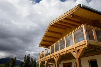 a wooden house with glass windows on top of it at Southern Lakes Resort in Tagish