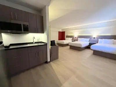a hotel room with two beds and a kitchen at Westport Inn in Grande Prairie