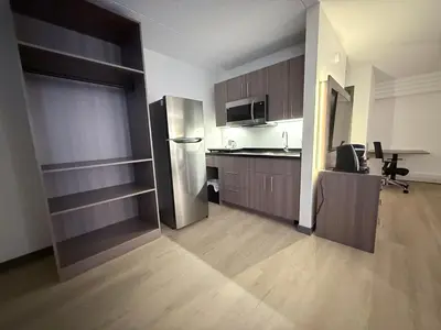 a kitchen with a stainless steel refrigerator and wooden cabinets at Westport Inn in Grande Prairie