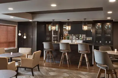 a restaurant with tables and chairs and a bar at Microtel Inn & Suites by Wyndham Bonnyville in Bonnyville