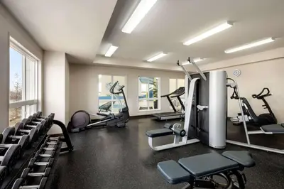 a gym with several treadmills and machines in a room at Microtel Inn & Suites by Wyndham Bonnyville in Bonnyville