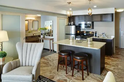 a kitchen with a large island in a living room at Pomeroy Inn and Suites Vermilion in Vermilion