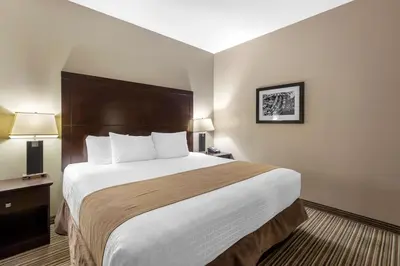 a hotel room with a large bed and two lamps at Best Western PLUS Fort Saskatchewan Inn & Suites in Fort Saskatchewan