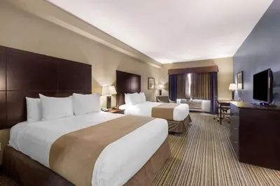 a hotel room with two beds and a flat screen tv at Best Western PLUS Fort Saskatchewan Inn & Suites in Fort Saskatchewan