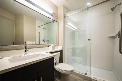 a bathroom with a sink toilet and a shower at Candlewood Suites West Edmonton - Mall Area by IHG in Edmonton