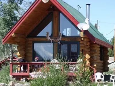 a log cabin with a green and red roof at Nimpo Lake Resort in Nimpo Lake