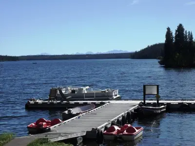 a dock with boats on a large lake at Nimpo Lake Resort in Nimpo Lake
