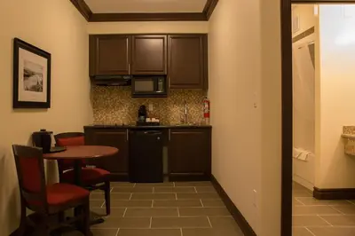 a small kitchen with a small table and a counter top at Chateau Nova Peace River in Peace River