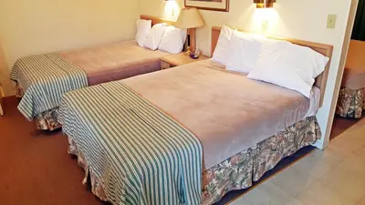 a hotel room with two beds in a room at Badlands Motel in Drumheller