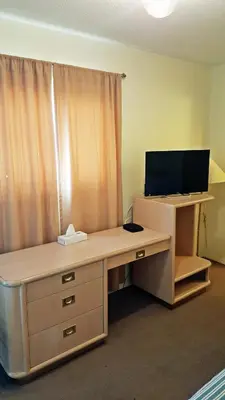 an office with a desk with a computer and a monitor at Badlands Motel in Drumheller