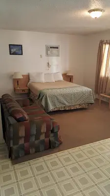 a hotel room with a bed and a couch at Badlands Motel in Drumheller