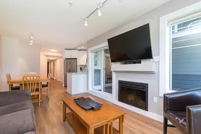 a living room with a fireplace with a flat screen tv at Pacific Shores Resort & Spa in Nanoose Bay