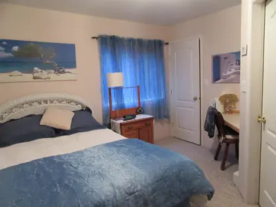 a bedroom with a bed and a table and a desk at Davis Bay Bed & Breakfast in Sechelt