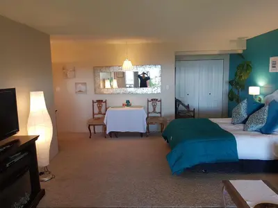 a bedroom with a bed and a table and a mirror at Davis Bay Bed & Breakfast in Sechelt