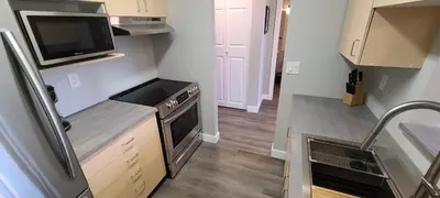 a small kitchen with a stove and a microwave at Howe Street Apartment with Views in Vancouver