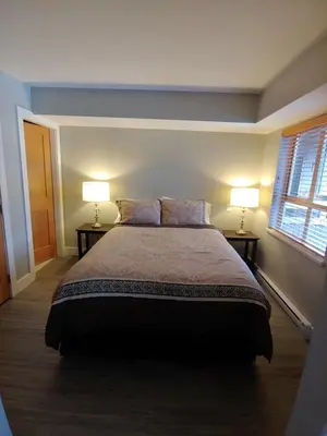 a bedroom with a large bed and two lamps at Tyndalstone Lodge 3 Bedroom in the Heart of Village North Whistler in Whistler