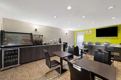 a dining room with tables and chairs and a restaurant at Super 8 by Wyndham Fort McMurray in Fort McMurray