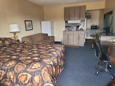 a hotel room with a bed and a kitchen at Dockside Inn in Cold Lake