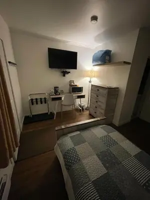 a bedroom with a bed and a desk with a television at Sunset Motel in Cache Creek