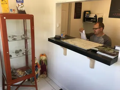 a man standing at a counter in front of a mirror at Sunset Motel in Cache Creek