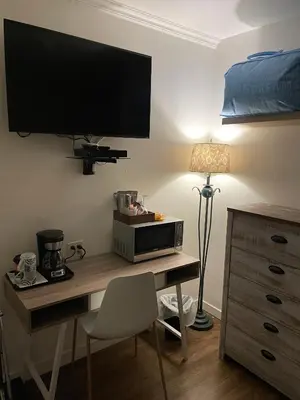 a room with a desk with a television and a microwave at Sunset Motel in Cache Creek
