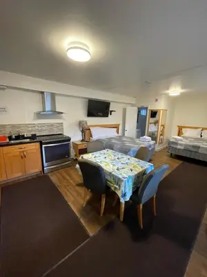 a room with a table and chairs and a bedroom at Sunset Motel in Cache Creek