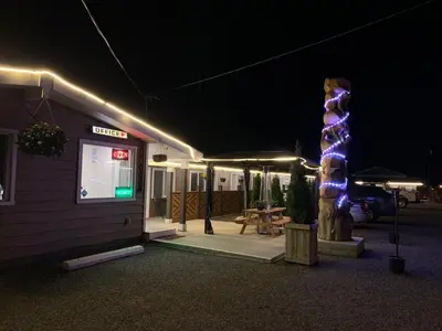 a building with a lit up sign next to a building with a lighted at Sunset Motel in Cache Creek
