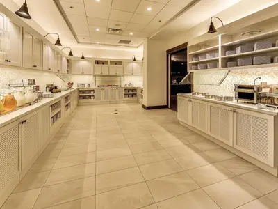 a large kitchen with white cabinets and tile floors at Hyatt Place Edmonton West in Edmonton
