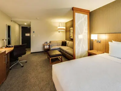 a hotel room with a bed and a couch at Hyatt Place Edmonton West in Edmonton