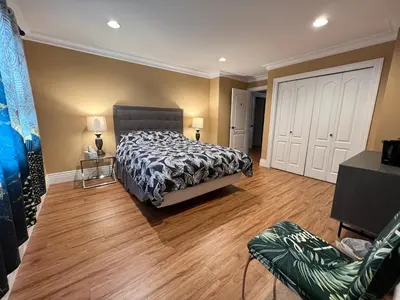a bedroom with a bed and a wooden floor at Vancouver Luxury Homestay in Richmond