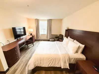 a hotel room with a bed and a desk and a television at West Edmonton Mall Inn in Edmonton