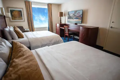 a hotel room with two beds and a desk at West Edmonton Mall Inn in Edmonton