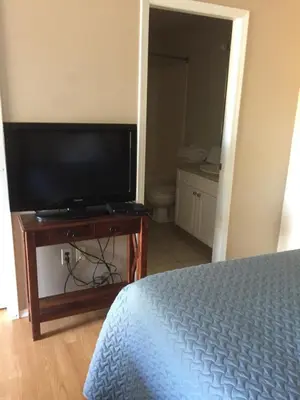 a bedroom with a flat screen tv and a bed at Kacee's Northern Suites in Fort Nelson