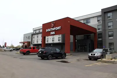 a shopping center with cars parked in a parking lot at Southfort Inn in Fort Saskatchewan