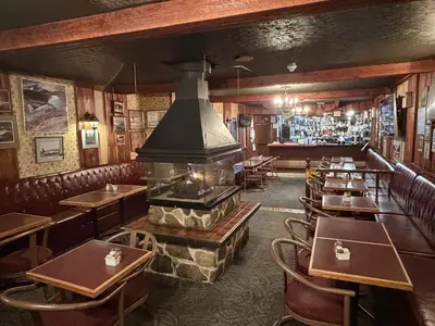 a restaurant with a fireplace and tables and chairs at Airport Chalet in Whitehorse