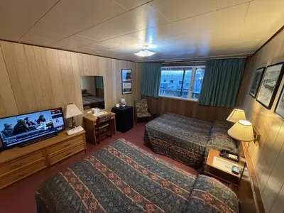 a hotel room with two beds and a flat screen tv at Airport Chalet in Whitehorse