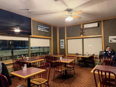 a dining room with tables and chairs and a ceiling fan at Airport Chalet in Whitehorse