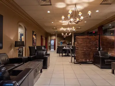a dining room with a table and chairs and a chandelier at Carriage House Hotel and Conference Centre in Calgary
