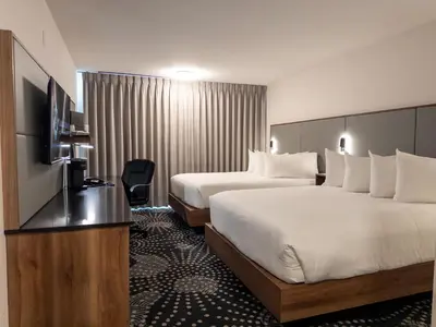 a hotel room with two beds and a television at Carriage House Hotel and Conference Centre in Calgary
