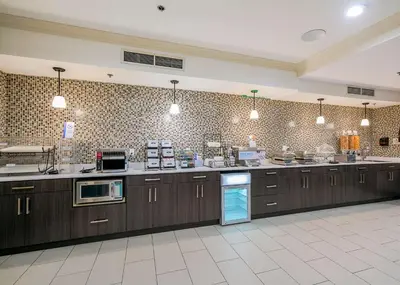 a large kitchen with wooden cabinets and appliances at Best Western Peace Arch Inn in Surrey