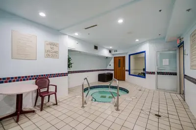 a bathroom with a tub with a table and a chair at Best Western Peace Arch Inn in Surrey