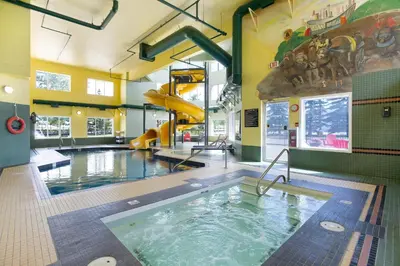 a swimming pool with a slide in a building at Super 8 by Wyndham Calgary Shawnessy Area in Calgary