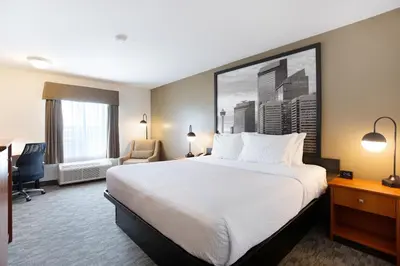 a hotel room with a bed and a desk at Super 8 by Wyndham Calgary Shawnessy Area in Calgary