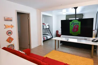 a living room with a red couch and a tv at Super 8 by Wyndham Calgary Shawnessy Area in Calgary