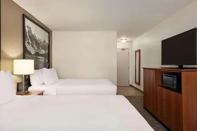 a hotel room with two beds and a flat screen tv at Super 8 by Wyndham Calgary Shawnessy Area in Calgary