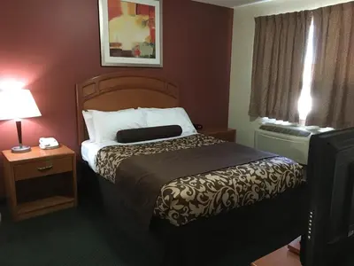 a hotel room with a bed and a television at Western Valley Inn in Valleyview