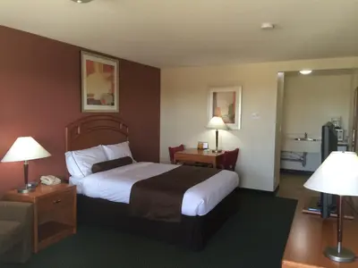a hotel room with a bed and two lamps at Western Valley Inn in Valleyview