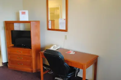 a desk with a television and a chair in a room at Economy Inn in Edmonton