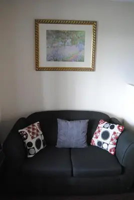 a black couch with pillows in a living room at Economy Inn in Edmonton